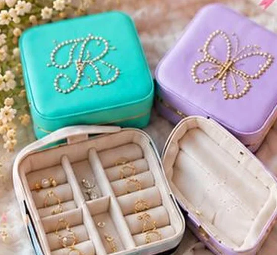 Teal and lilac jewellery boxes decorated with pearl initials and a butterfly