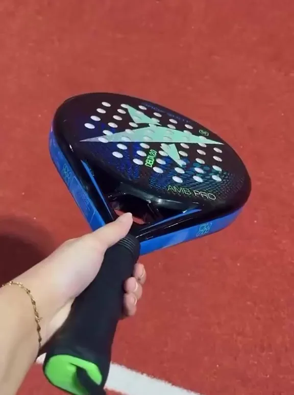 A padel racket and ball on the court surface